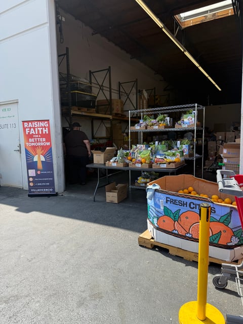 Outdoor food market stand with fresh produce display shelving and citrus crates under a covered structure