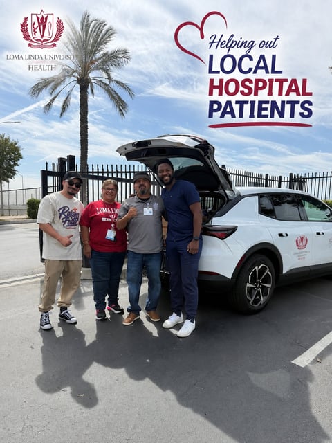 Four volunteers stand next to a white car at Loma Linda University Health, supporting a local hospital patient assistance program